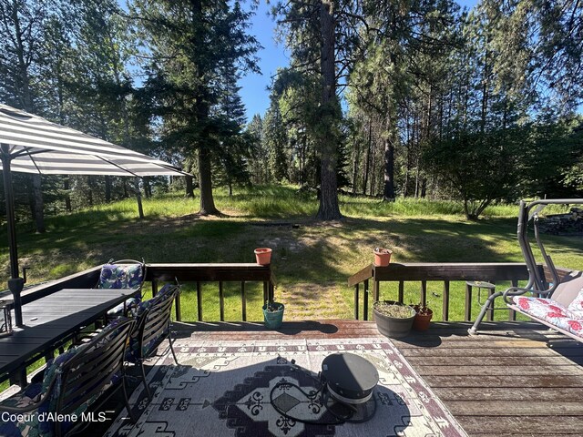 1150 Elm Dr, Saint Maries, ID 83861 - deck with outdoor dining area and a yard