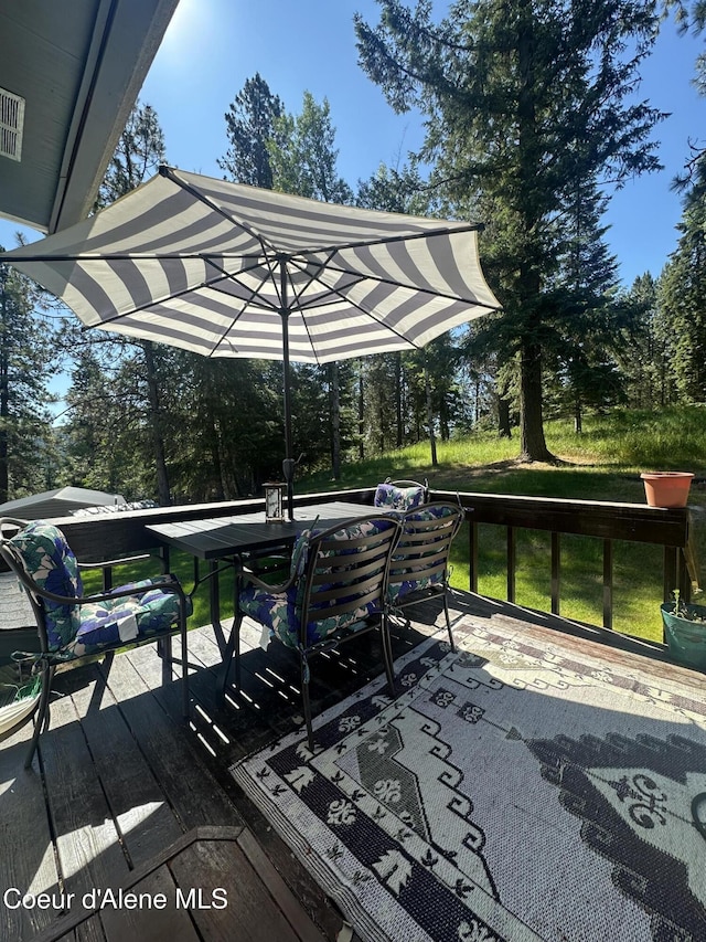 1150 Elm Dr, Saint Maries, ID 83861 - wooden deck with outdoor dining area and view of scattered trees