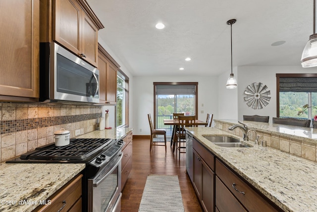 13408 E Copper River Ln, Spokane, WA 99206 - kitchen with appliances with stainless steel finishes, decorative backsplash, dark wood-style floors, recessed lighting, and light stone countertops