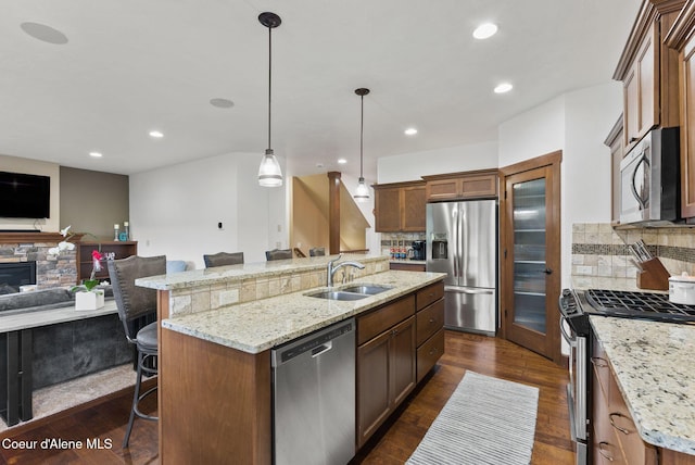 13408 E Copper River Ln, Spokane, WA 99206 - kitchen featuring appliances with stainless steel finishes, open floor plan, a kitchen island with sink, a kitchen breakfast bar, and dark wood-style flooring