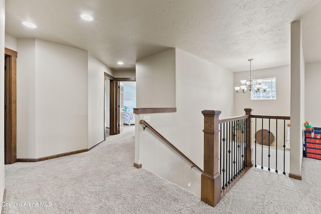 13408 E Copper River Ln, Spokane, WA 99206 - hallway with carpet flooring, an upstairs landing, recessed lighting, a chandelier, and a textured ceiling