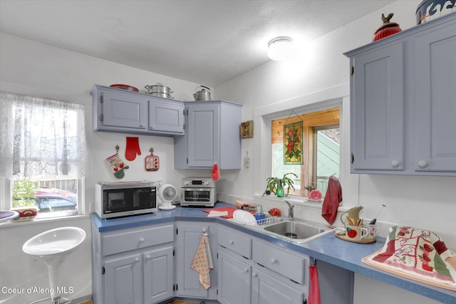1505 N 3rd, Coeur Dalene, ID 83814 - kitchen with stainless steel microwave, light countertops, and gray cabinets