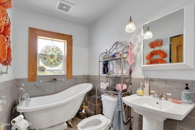1505 N 3rd, Coeur Dalene, ID 83814 - full bathroom with tile walls, a freestanding bath, a wainscoted wall, and tile patterned floors