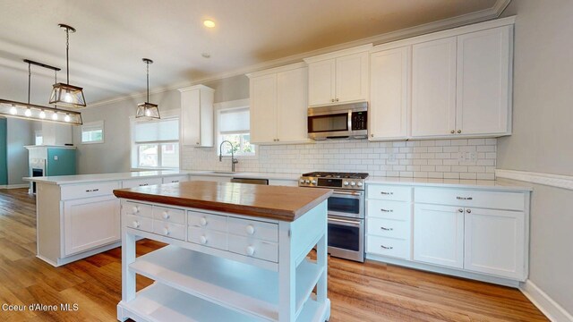 1121 E Indiana Ave, Coeur Dalene, ID 83814 - kitchen featuring stainless steel appliances, a peninsula, open shelves, white cabinets, and ornamental molding