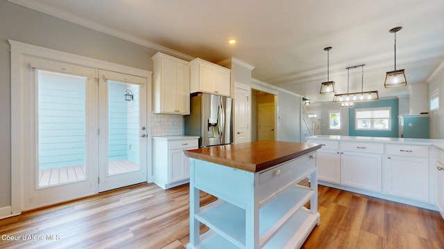 1121 E Indiana Ave, Coeur Dalene, ID 83814 - kitchen with stainless steel fridge with ice dispenser, open shelves, white cabinetry, ornamental molding, and light wood-style floors