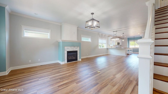 1121 E Indiana Ave, Coeur Dalene, ID 83814 - unfurnished living room with a chandelier, ornamental molding, a large fireplace, light wood-style floors, and stairway