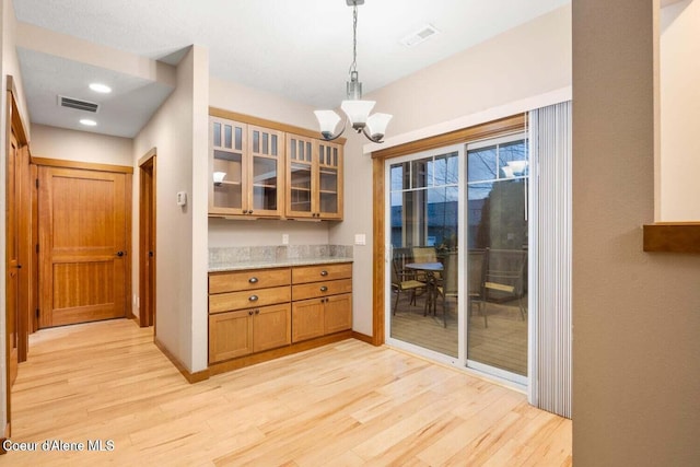 2848 N O Connor Blvd, Post Falls, ID 83854 - kitchen with light wood-type flooring, a chandelier, glass insert cabinets, decorative light fixtures, and recessed lighting