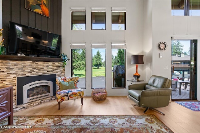 5276 W Racquet Rd Unit 9, Rathdrum, ID 83858 - living area with a towering ceiling, wood finished floors, healthy amount of natural light, and a fireplace
