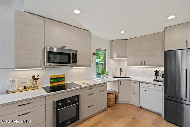 5276 W Racquet Rd Unit 9, Rathdrum, ID 83858 - kitchen with black appliances, tasteful backsplash, light countertops, light wood-style flooring, and recessed lighting