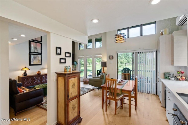 5276 W Racquet Rd Unit 9, Rathdrum, ID 83858 - dining area featuring a wall mounted air conditioner, light wood finished floors, recessed lighting, and a high ceiling