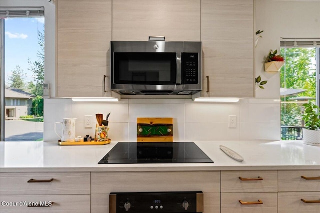 5276 W Racquet Rd Unit 9, Rathdrum, ID 83858 - kitchen with stainless steel microwave, black electric cooktop, wall oven, light countertops, and backsplash
