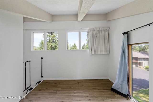 5276 W Racquet Rd Unit 9, Rathdrum, ID 83858 - empty room featuring wood finished floors, beam ceiling, and healthy amount of natural light
