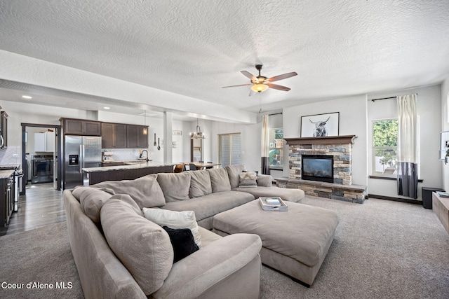 2499 N N Side Saddle Ln, Post Falls, ID 83854 - living room with ceiling fan, a textured ceiling, a stone fireplace, and carpet