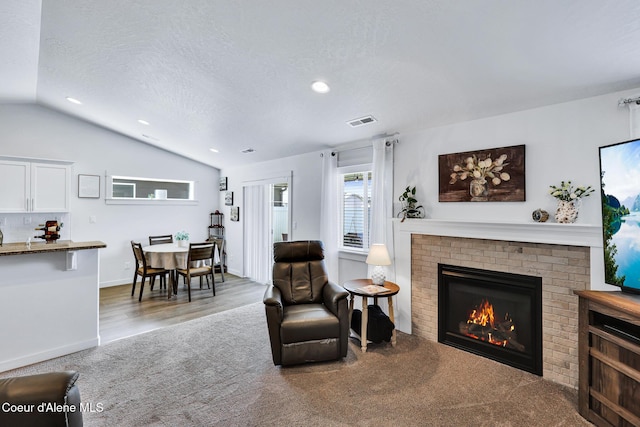 3631 N Britton Rd, Post Falls, ID 83854 - living area featuring carpet flooring, lofted ceiling, a brick fireplace, a textured ceiling, and recessed lighting