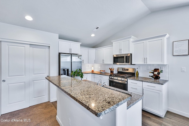 3631 N Britton Rd, Post Falls, ID 83854 - kitchen featuring stainless steel appliances, lofted ceiling, white cabinets, decorative backsplash, and dark stone counters
