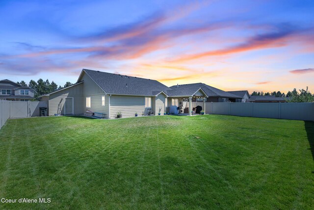 3631 N Britton Rd, Post Falls, ID 83854 - back of house at dusk featuring a fenced backyard and roof with shingles