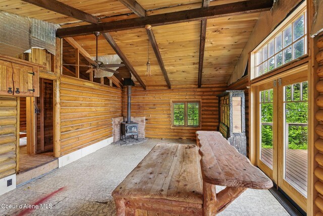 527 W Seneacquoteen, Priest River, ID 83856 - unfurnished living room featuring a wood stove, log walls, high vaulted ceiling, a wooden ceiling with exposed beams, and a ceiling fan