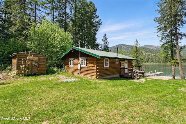 527 W Seneacquoteen, Priest River, ID 83856 - view of side of home featuring log exterior, a water and mountain view, a yard, and a storage unit