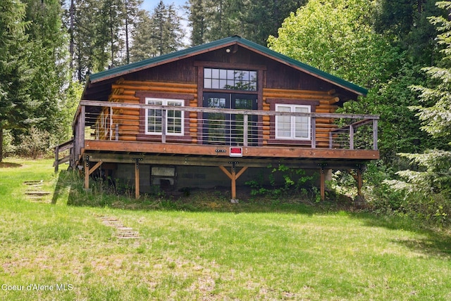527 W Seneacquoteen, Priest River, ID 83856 - view of front of home featuring log exterior, a deck, and a front lawn
