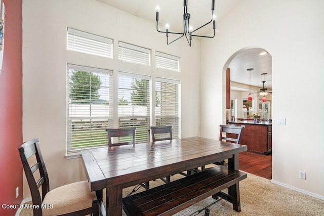 8136 Salmonberry Lp, Hayden, ID 83835 - dining area with arched walkways, a chandelier, a high ceiling, carpet floors, and ceiling fan