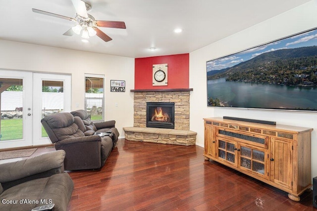 8136 Salmonberry Lp, Hayden, ID 83835 - living room featuring a stone fireplace, recessed lighting, dark wood-style flooring, a ceiling fan, and french doors