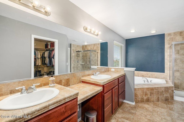 8136 Salmonberry Lp, Hayden, ID 83835 - bathroom featuring a stall shower, vanity, a garden tub, a walk in closet, and tile patterned flooring