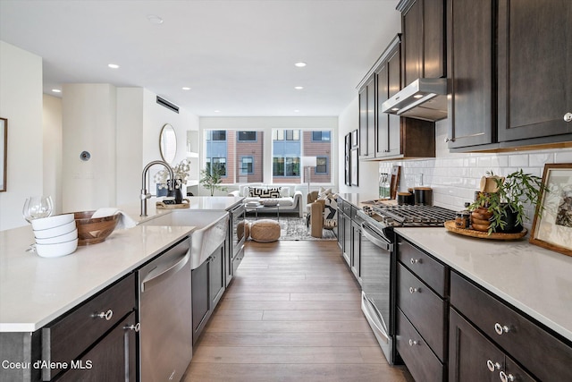 2756 W Lumber Ln Unit 7, Coeur Dalene, ID 83814 - kitchen featuring appliances with stainless steel finishes, extractor fan, wood finished floors, dark brown cabinetry, and light countertops