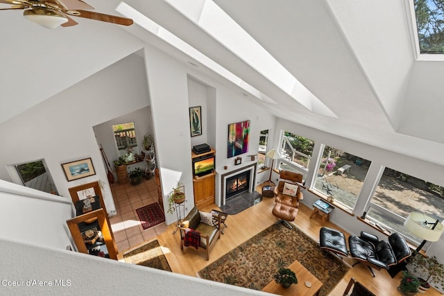 38 S Quail Run Unit B, Sandpoint, ID 83864 - living area with a skylight, healthy amount of natural light, a lit fireplace, high vaulted ceiling, and wood finished floors