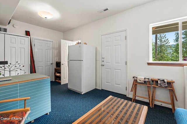 38 S Quail Run Unit B, Sandpoint, ID 83864 - kitchen with freestanding refrigerator, dark carpet, and white cabinetry