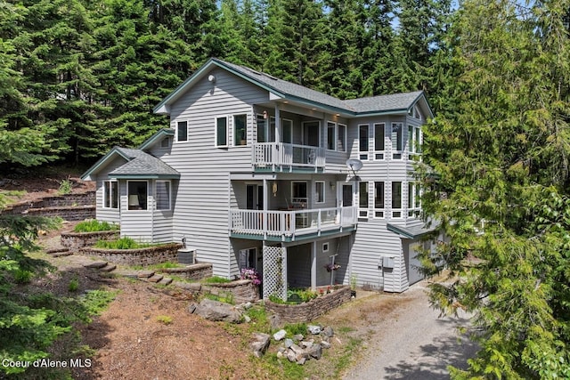 38 S Quail Run Unit B, Sandpoint, ID 83864 - rear view of property with a balcony, driveway, an attached garage, and roof with shingles