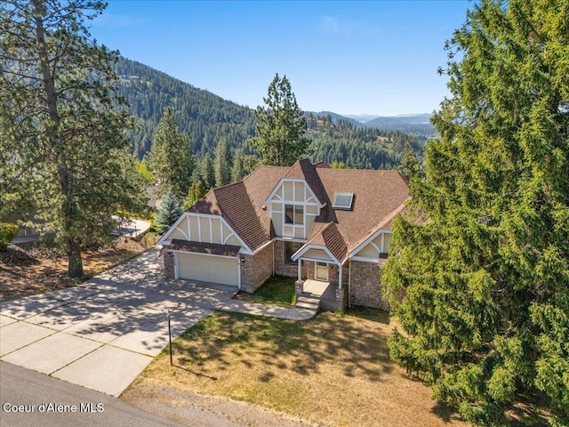 2699 E Packsaddle Dr, Coeur Dalene, ID 83815 - english style home with an attached garage, driveway, a wooded view, a mountain view, and stone siding
