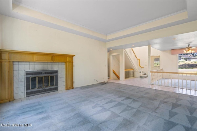 2699 E Packsaddle Dr, Coeur Dalene, ID 83815 - unfurnished living room featuring stairs, a raised ceiling, light colored carpet, ornamental molding, and a tiled fireplace