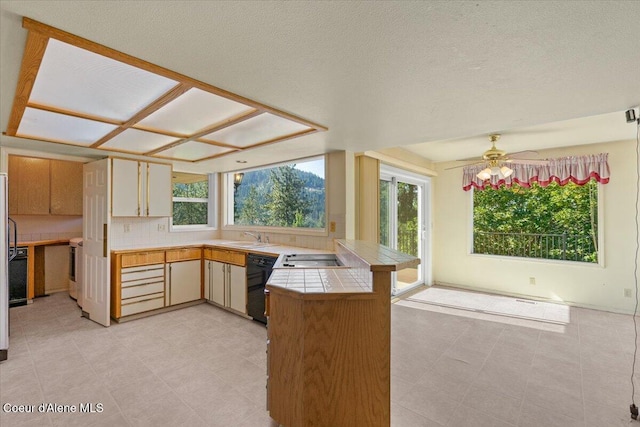 2699 E Packsaddle Dr, Coeur Dalene, ID 83815 - kitchen featuring a peninsula, tile counters, dishwasher, ceiling fan, and electric cooktop