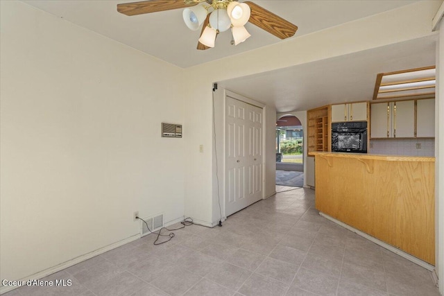 2699 E Packsaddle Dr, Coeur Dalene, ID 83815 - kitchen with oven, arched walkways, a ceiling fan, a breakfast bar area, and light countertops