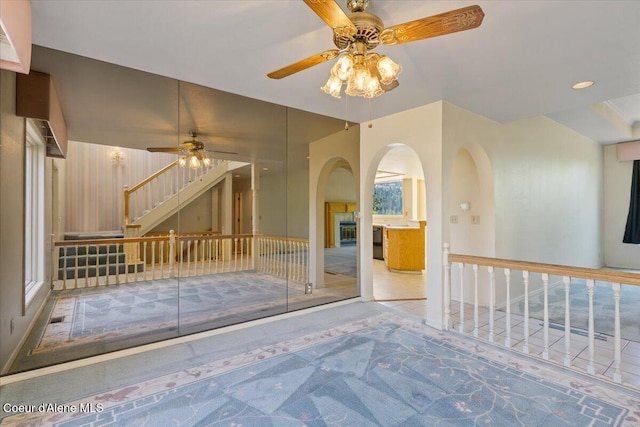2699 E Packsaddle Dr, Coeur Dalene, ID 83815 - carpeted spare room featuring ceiling fan, arched walkways, and stairs