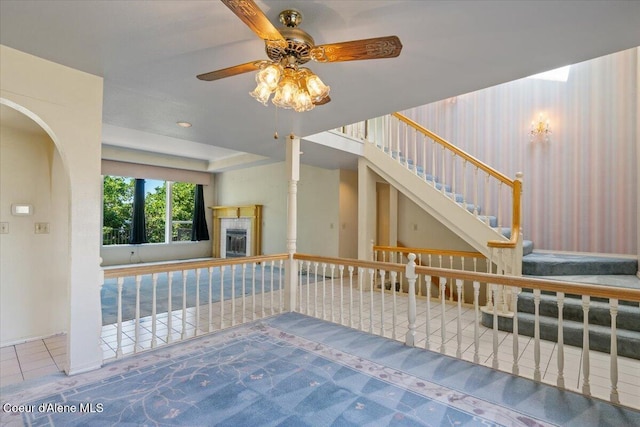 2699 E Packsaddle Dr, Coeur Dalene, ID 83815 - unfurnished living room with ceiling fan, a tile fireplace, arched walkways, and stairs