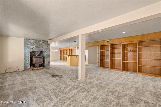 2699 E Packsaddle Dr, Coeur Dalene, ID 83815 - unfurnished living room with a textured ceiling, a wood stove, and carpet flooring