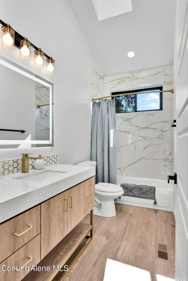 114 E Hattie, Coeur Dalene, ID 83814 - bathroom with vanity, shower / bath combination with curtain, wood finished floors, and a skylight