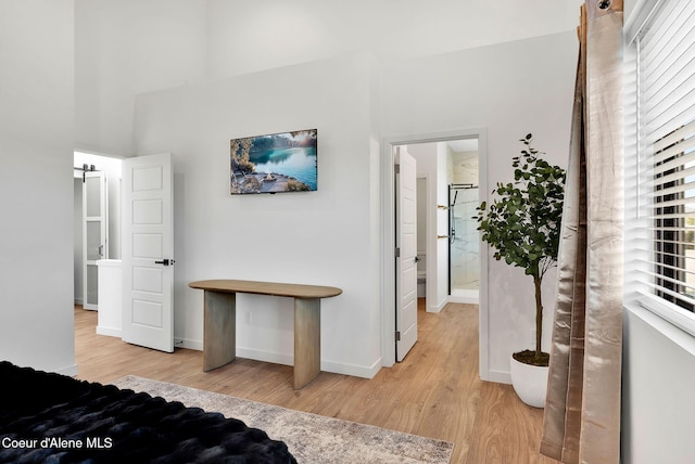 114 E Hattie, Coeur Dalene, ID 83814 - bedroom featuring light wood-type flooring, multiple windows, and a towering ceiling