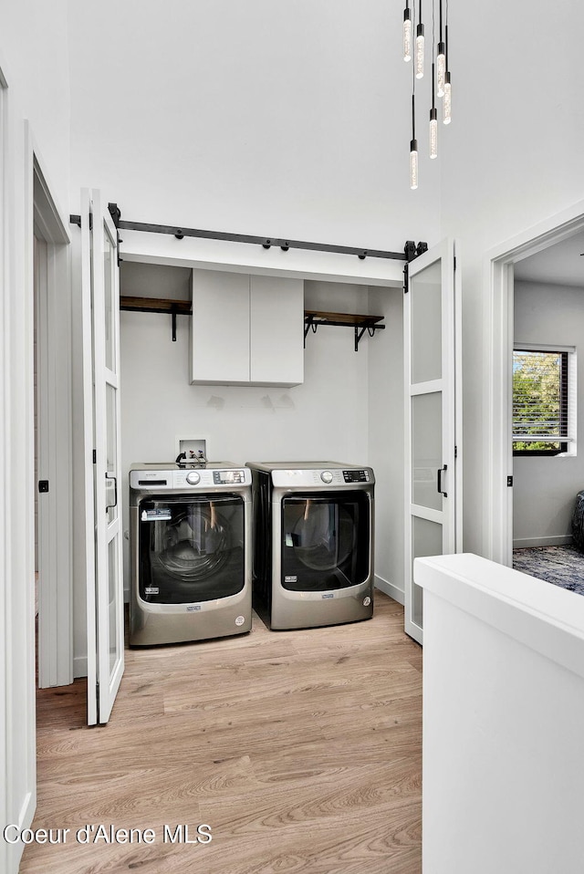 114 E Hattie, Coeur Dalene, ID 83814 - laundry area with independent washer and dryer, cabinet space, and light wood-style flooring