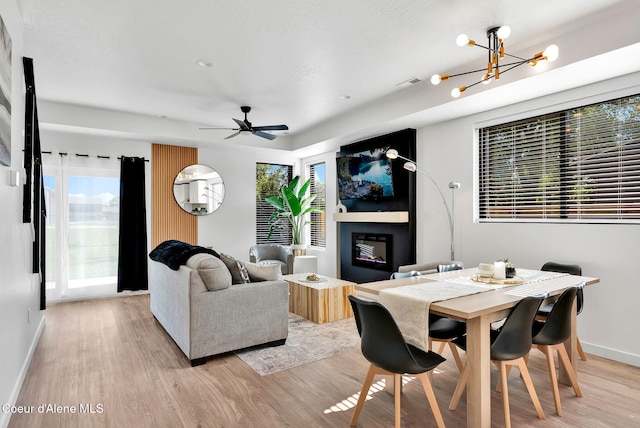 114 E Hattie, Coeur Dalene, ID 83814 - living area featuring light wood-type flooring, a glass covered fireplace, a chandelier, and ceiling fan