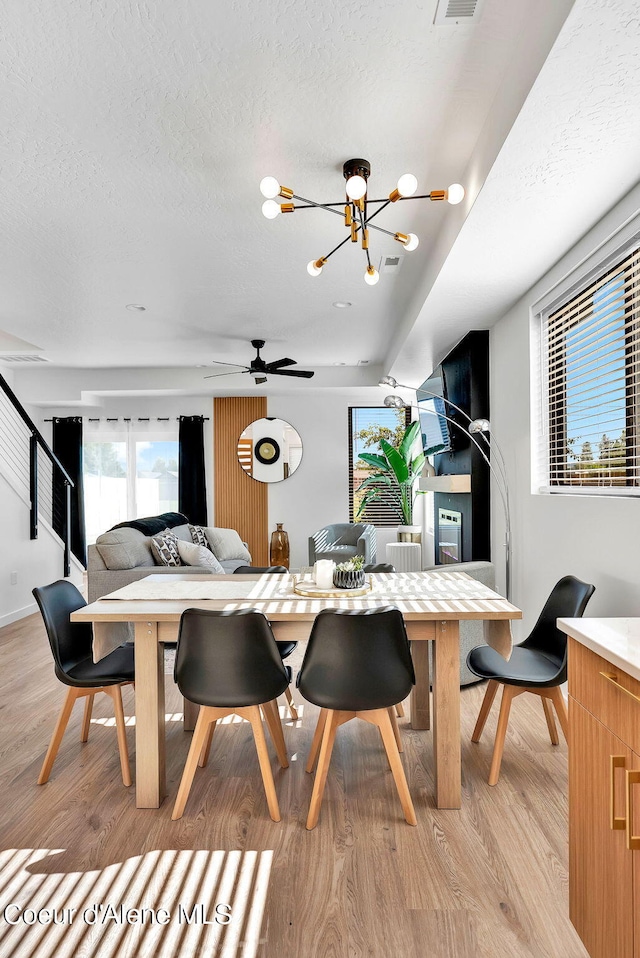 114 E Hattie, Coeur Dalene, ID 83814 - dining area with light wood-style floors, a chandelier, and a textured ceiling