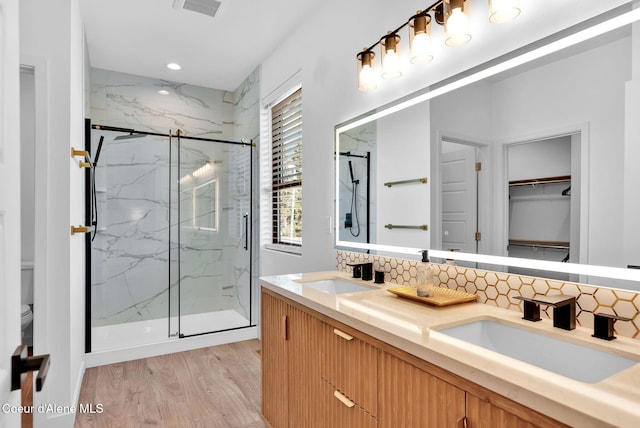 114 E Hattie, Coeur Dalene, ID 83814 - full bath featuring a marble finish shower, wood finished floors, tasteful backsplash, double vanity, and a spacious closet