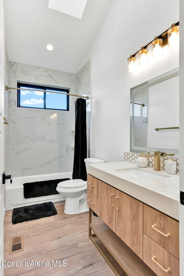 114 E Hattie, Coeur Dalene, ID 83814 - bathroom featuring vanity, shower / tub combo, wood finished floors, a skylight, and vaulted ceiling