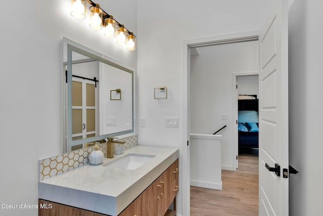114 E Hattie, Coeur Dalene, ID 83814 - bathroom featuring vanity, wood finished floors, and tasteful backsplash