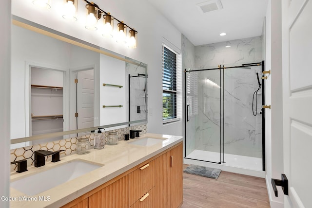 114 E Hattie, Coeur Dalene, ID 83814 - full bathroom with a marble finish shower, double vanity, wood finished floors, tasteful backsplash, and a spacious closet