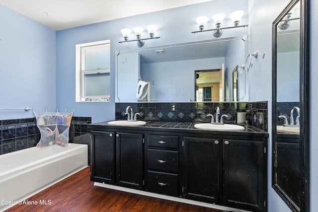 703 W Angus Ct, Post Falls, ID 83854 - full bath featuring double vanity, a bath, wood finished floors, and tasteful backsplash