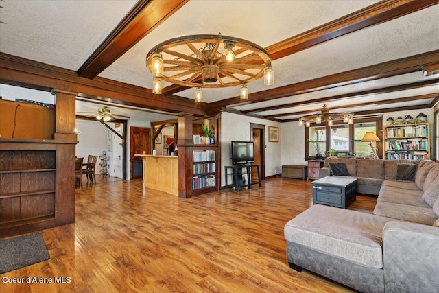 3297 Minaloosa Valley Rd, Plummer, ID 83851 - living room featuring crown molding, wood finished floors, beam ceiling, a ceiling fan, and a chandelier