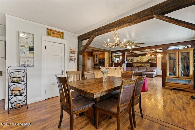 3297 Minaloosa Valley Rd, Plummer, ID 83851 - dining area with a chandelier, wood finished floors, a ceiling fan, ornamental molding, and beam ceiling