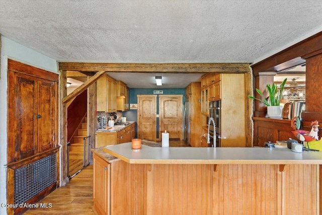 3297 Minaloosa Valley Rd, Plummer, ID 83851 - kitchen with a textured ceiling, light wood-type flooring, light countertops, appliances with stainless steel finishes, and a peninsula